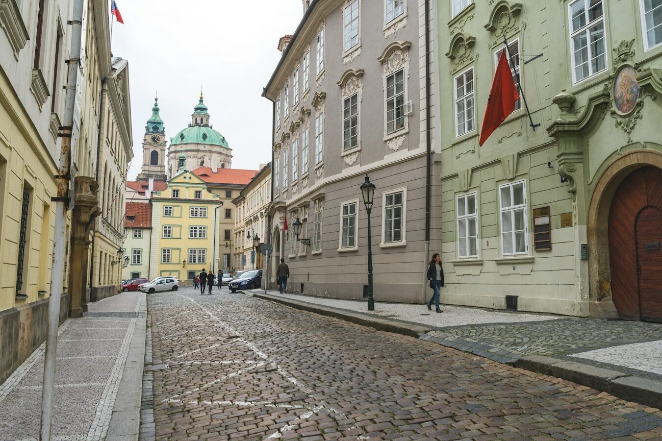 woman walking on street with red flag above her