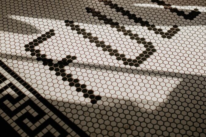 a woman standing on a tiled floor next to a doorway
